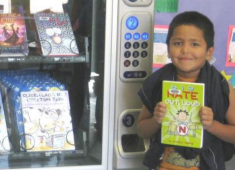 Child checking out a book at a Hayward Library book vending machine.